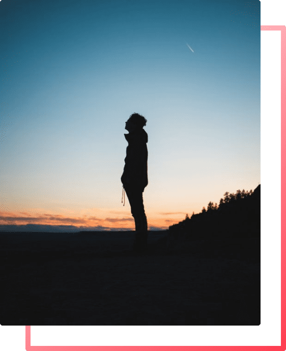 Silhouette of a man in nature looking at the sky feeling relaxed and free from stress, fear and anxiety.