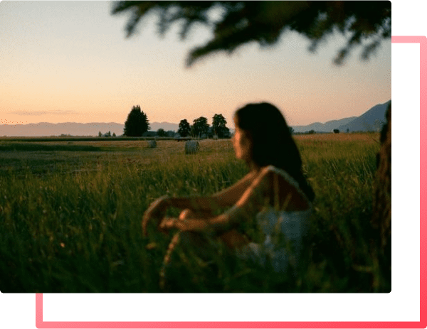 A woman in a field reflecting on her stress and anxiety and how to overcome her trauma.